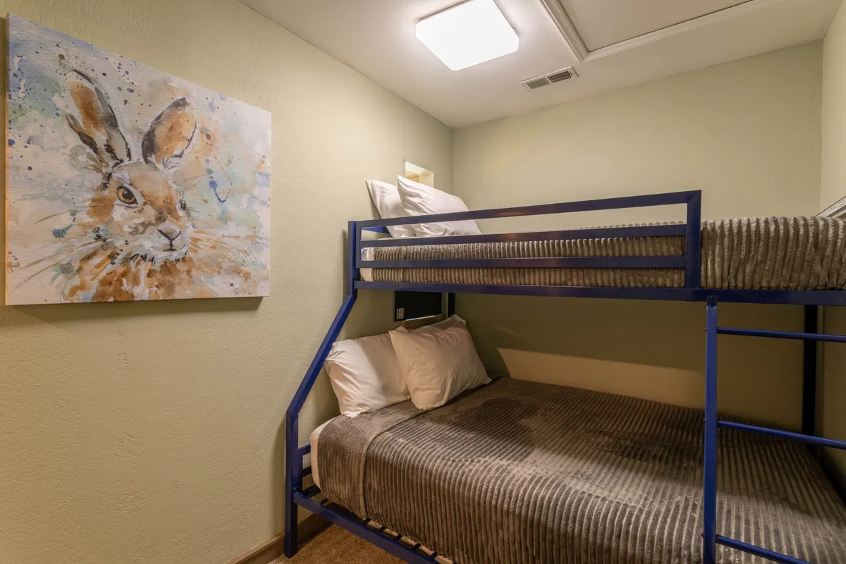 A cheerful and playful kids’ nook with a bunk bed, whimsical rabbit artwork, and a bright, relaxed atmosphere perfect for sleep, play, or downtime.