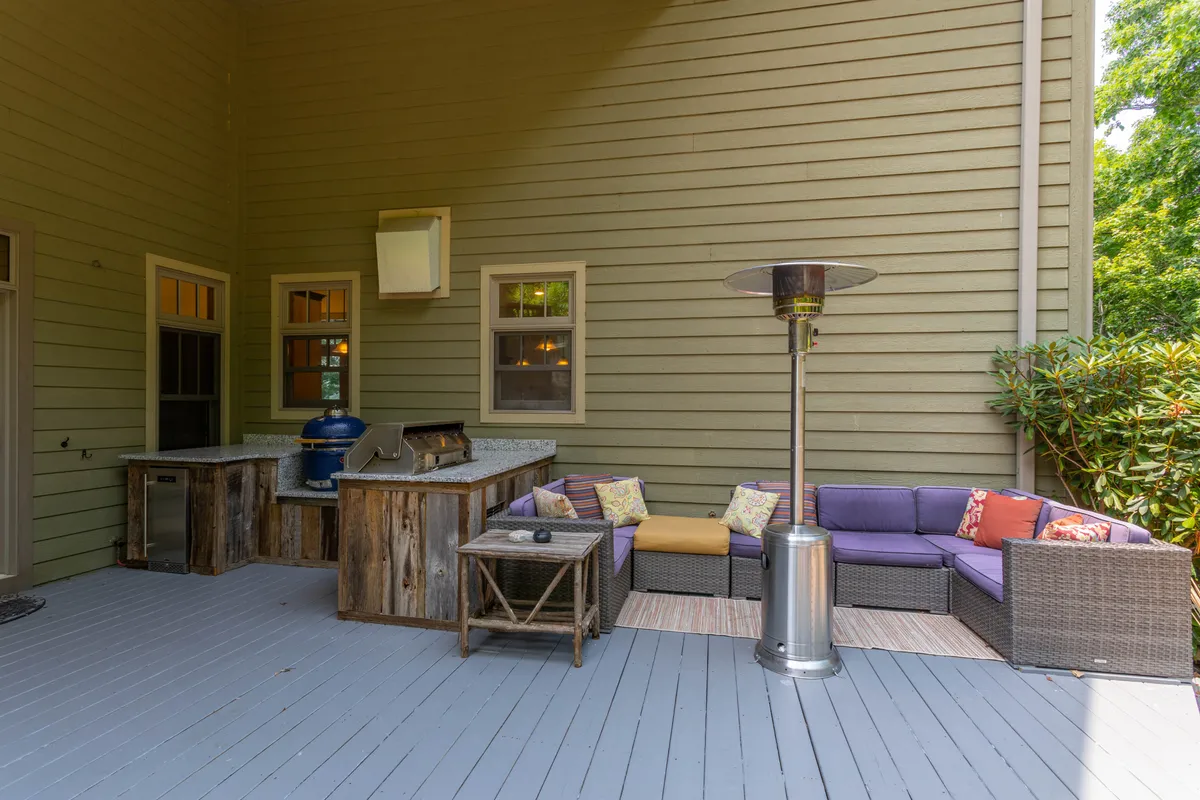 This exterior image showcases a well-equipped outdoor kitchen and a welcoming seating area under a patio heater. The space is designed for alfresco dining, social gatherings, and enjoying the mountain ambiance, embodying both comfort and elegance.